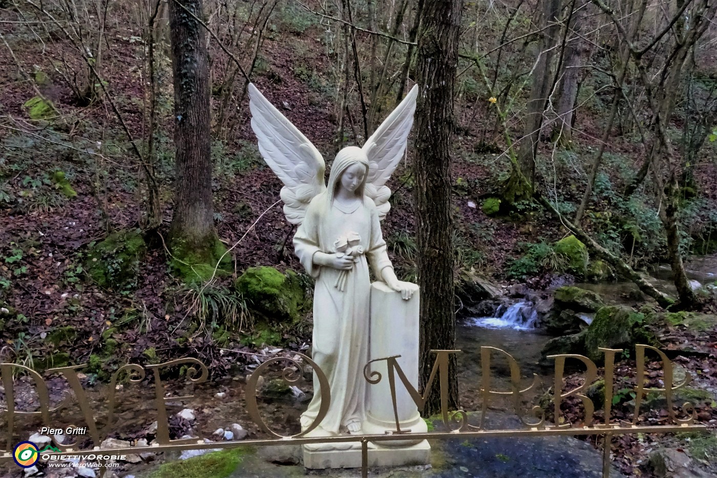 35 Un bianco angelo alato annuncia la Grotta della Madonna di Lourdes.JPG